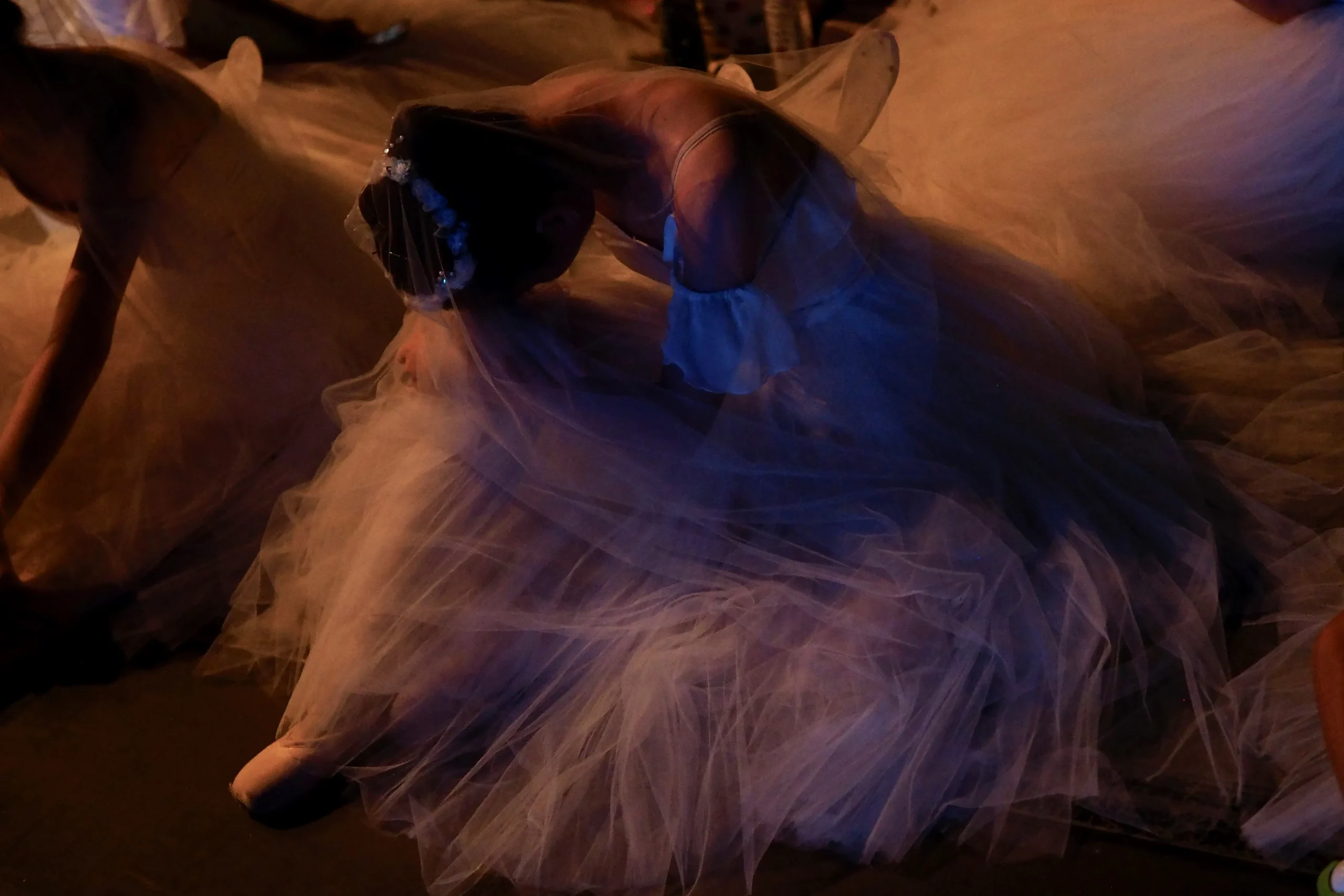 Dancers in motion, captured in warm low light.